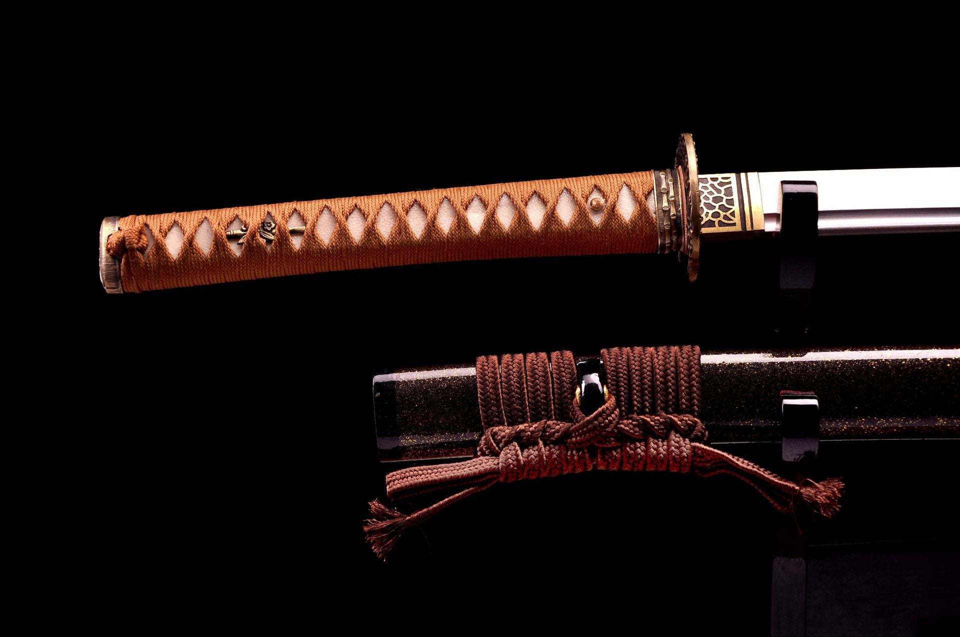Close-up of a samurai sword handle with intricate braided wrapping and a decorative sheath with tied cord.