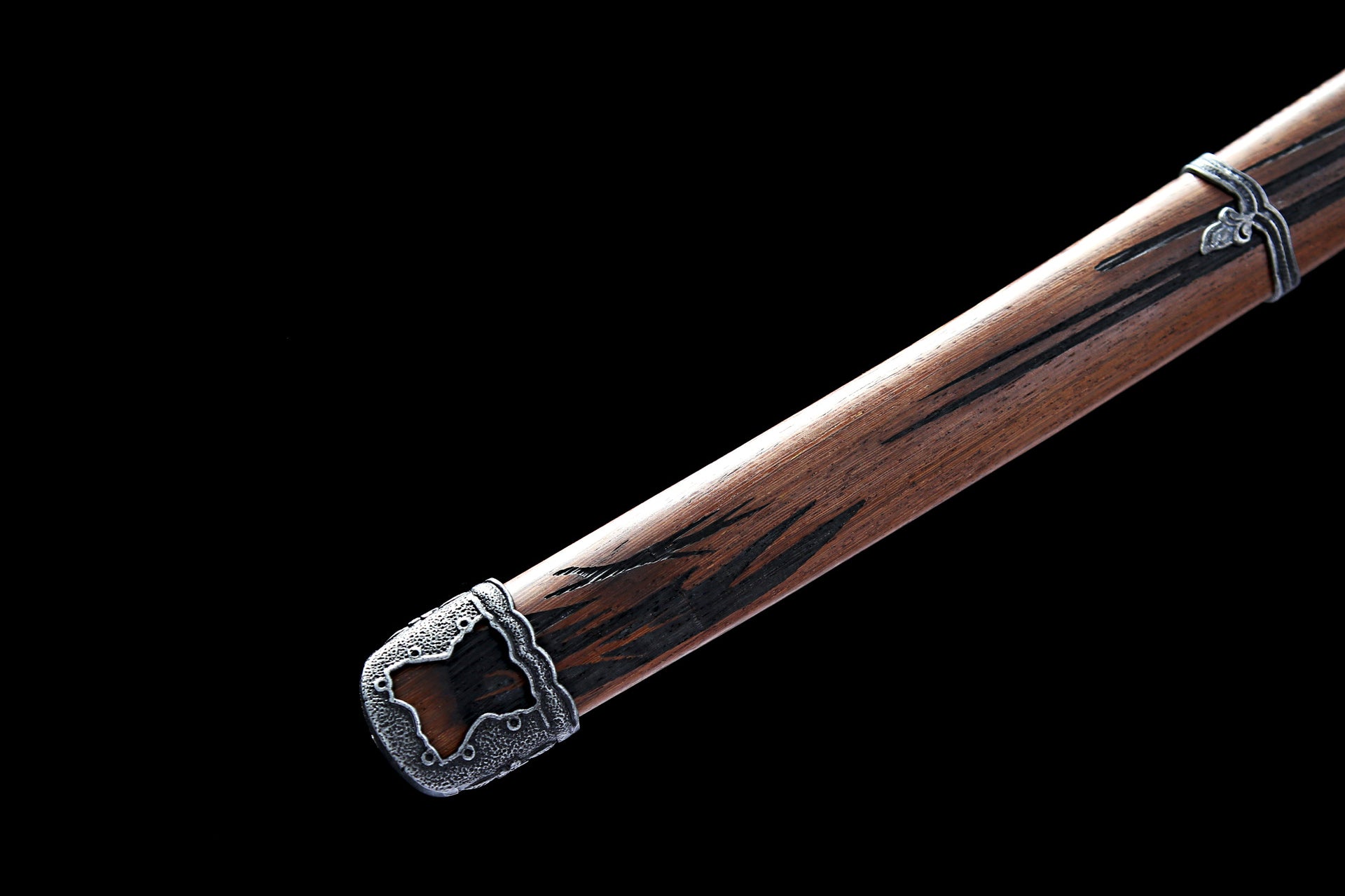 Close-up of Sekiro Mortal Blade scabbard end with detailed metal ornament and wooden texture.