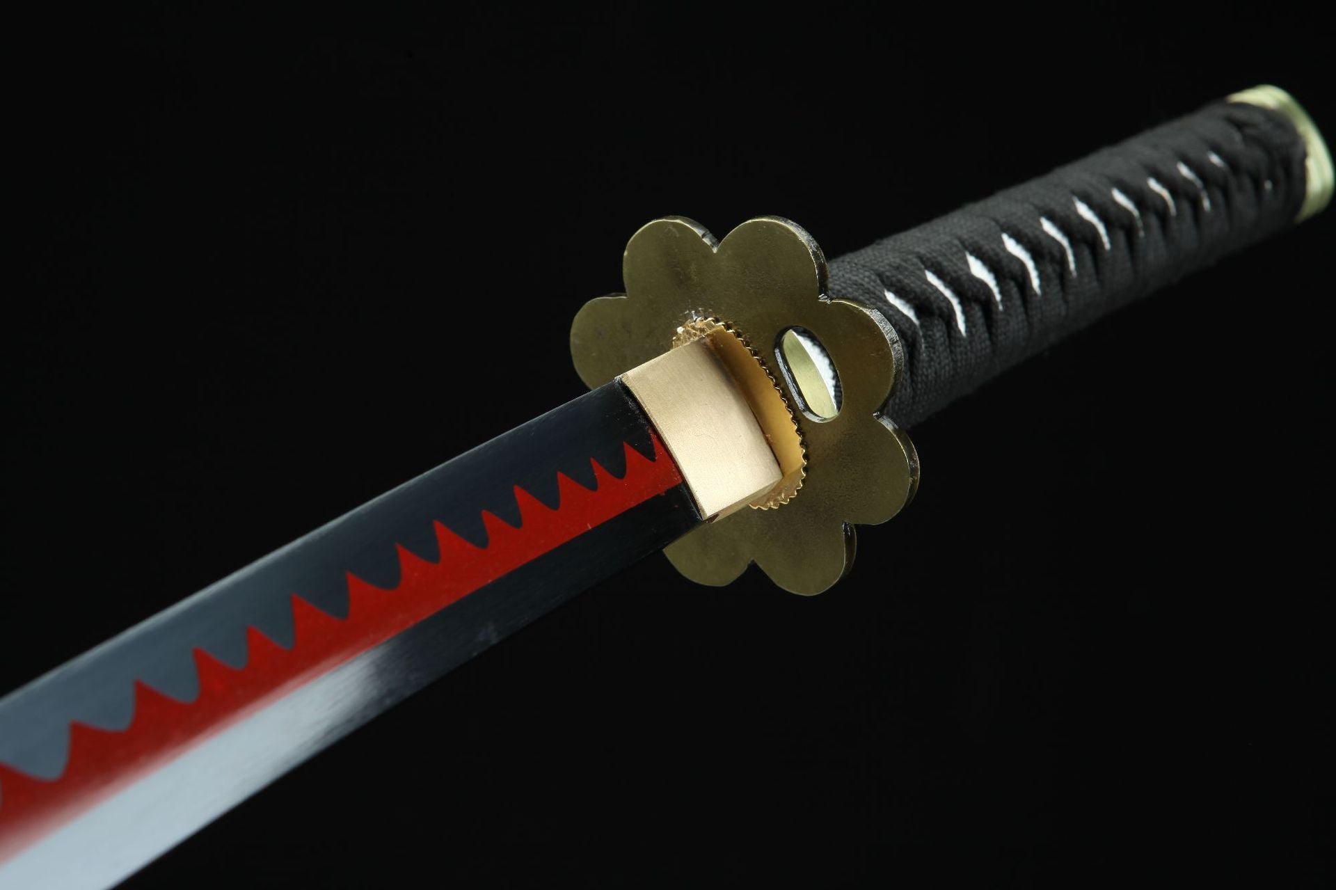 Close-up of Shusui sword blade with red hamon pattern and petal-shaped guard.