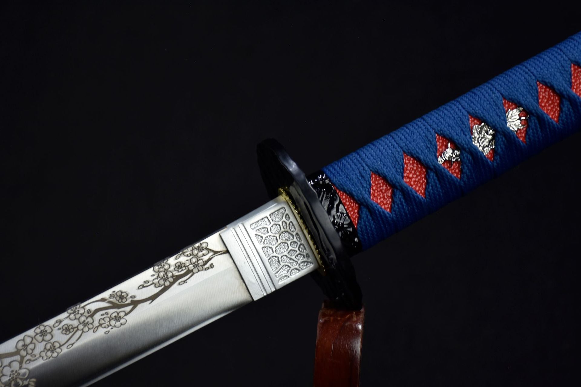 A close-up of the silver katana fuchi