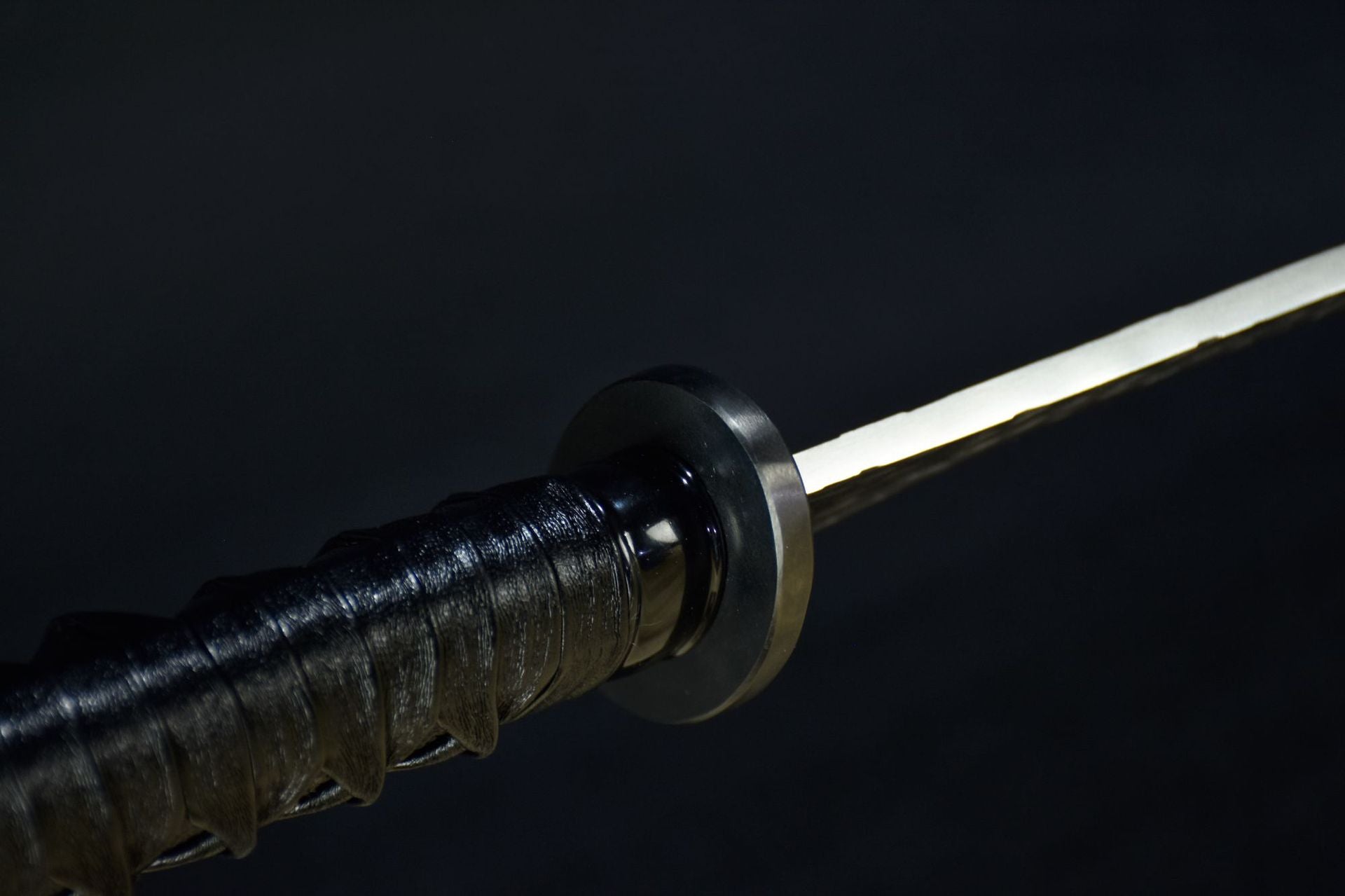 A small oval black tsuba on a samurai sword