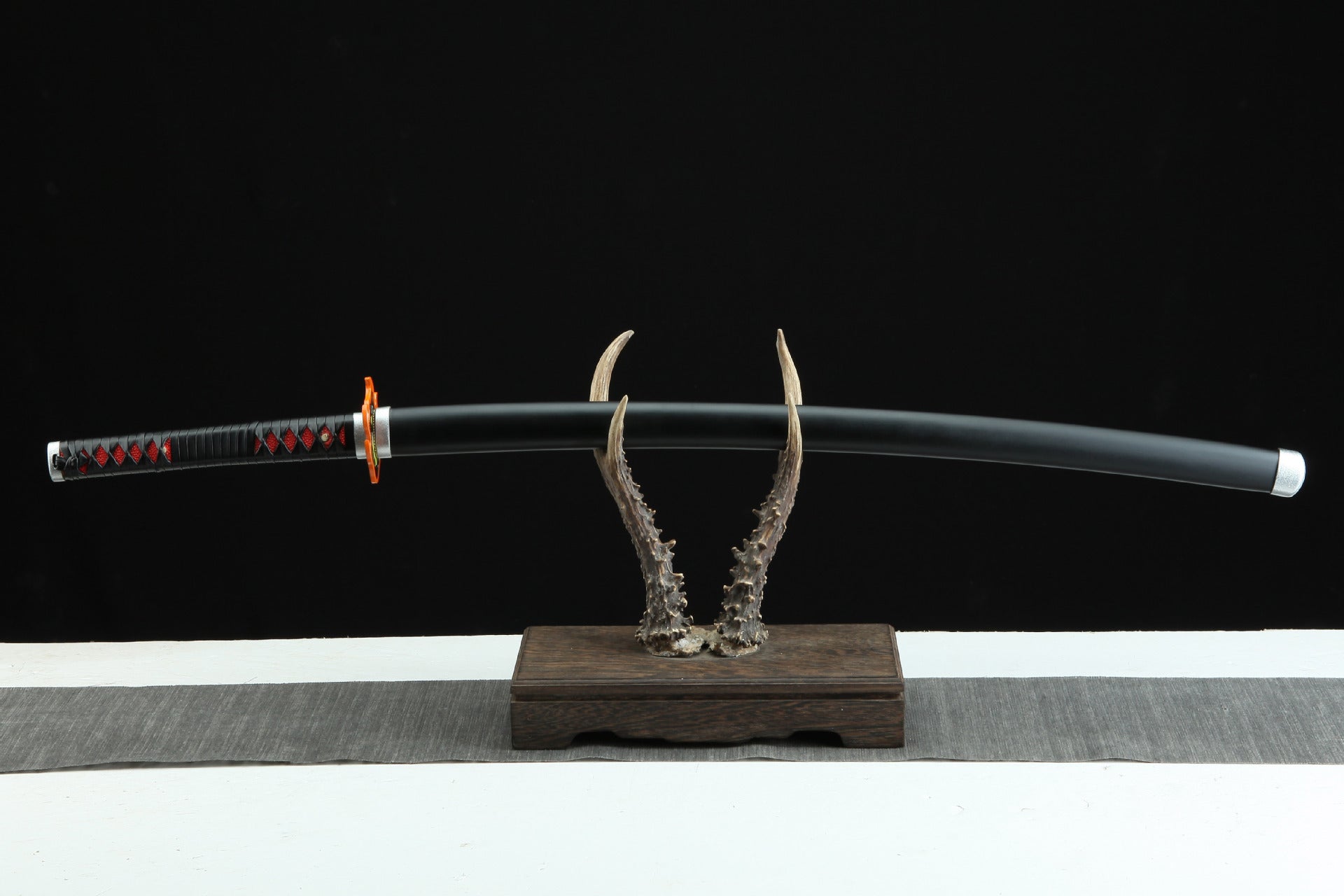 Tanjiro's Nichirin katana displayed on a sword rack.