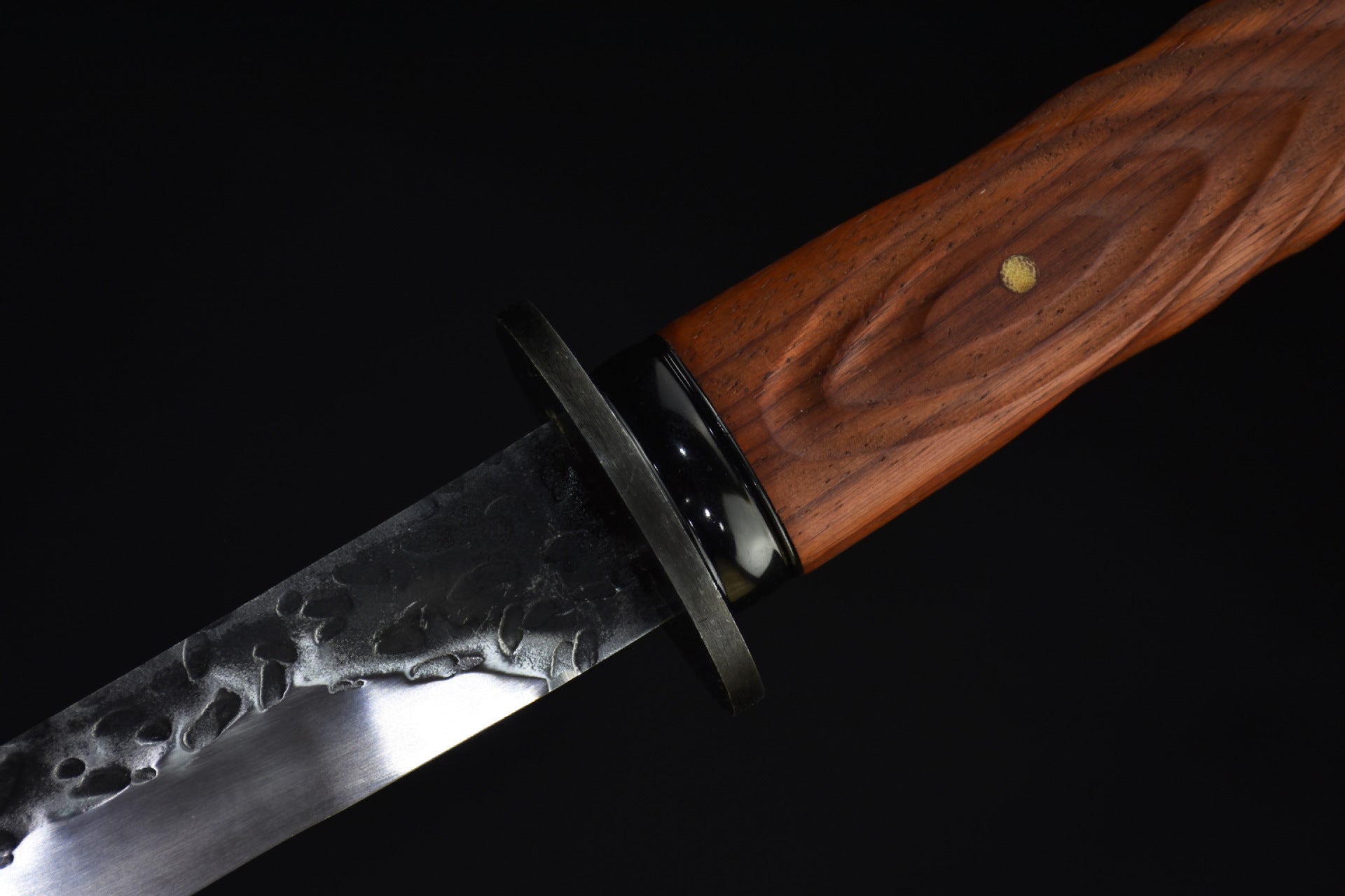 A detailed view of a katana with a wooden handle