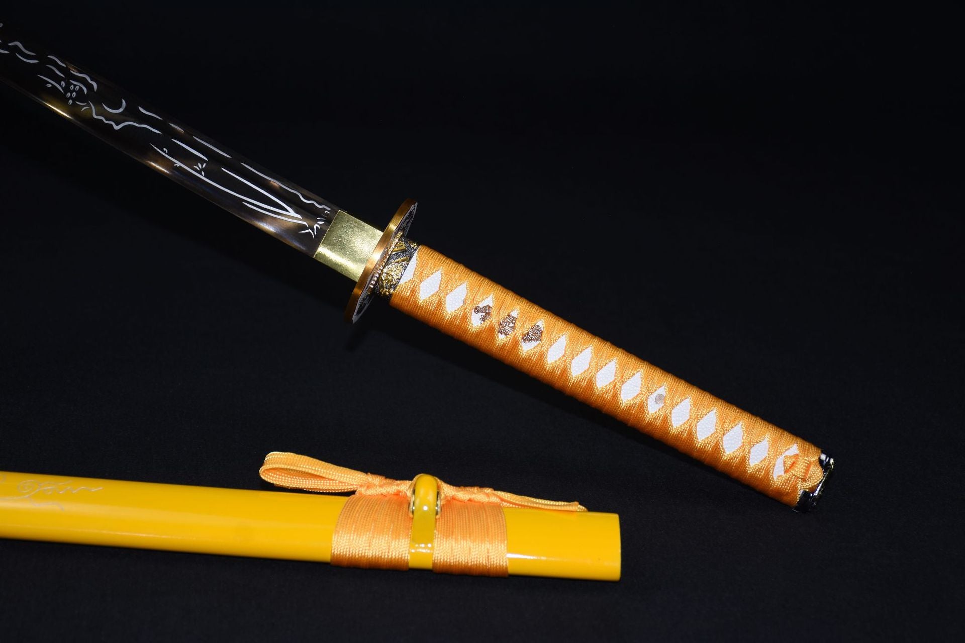 A yellow samurai sword and scabbard on a black background