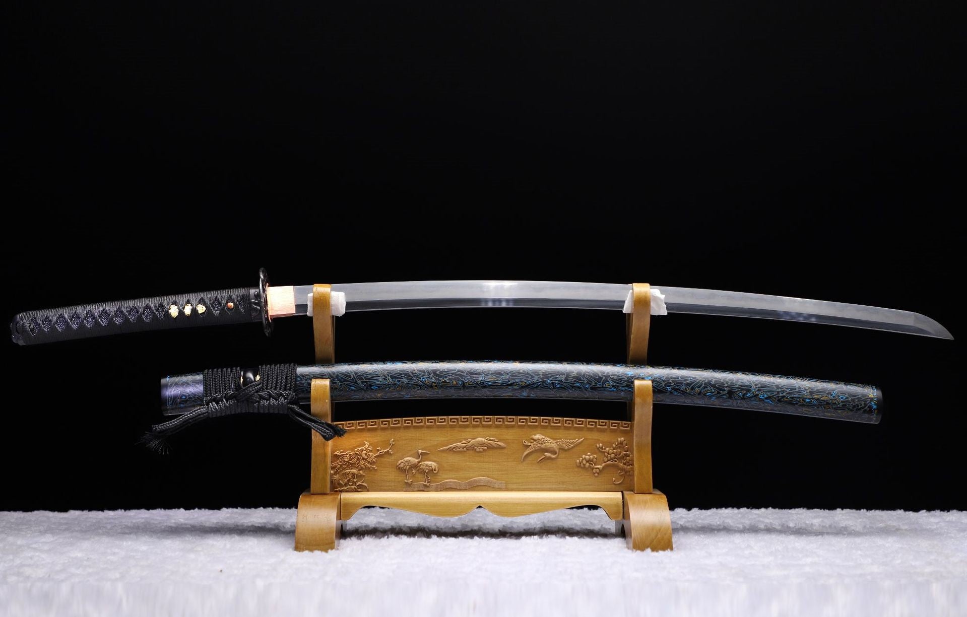 Samurai sword featuring a curved blade and detailed koshirae with bamboo and serpent motifs.