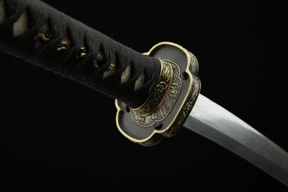 Close-up of a katana with a black handle wrap and intricately designed tsuba, capturing the authentic craftsmanship and fine details.