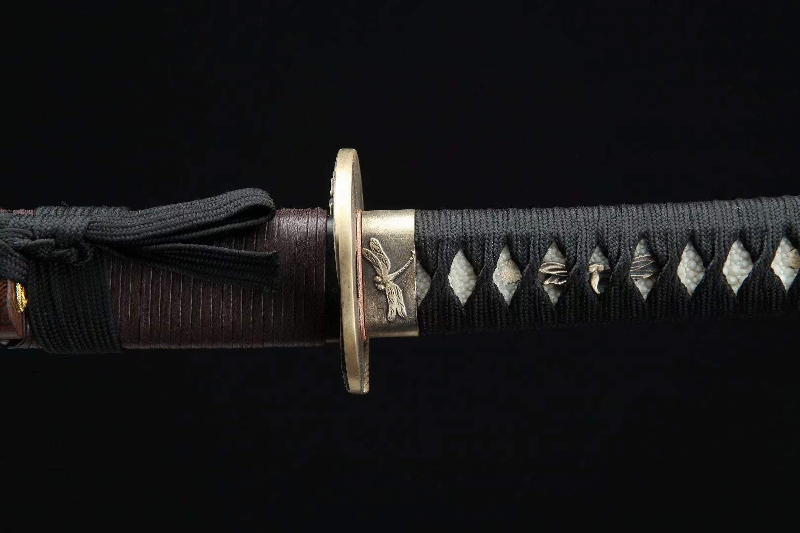 End cap of the Dragonfly Wakizashi handle featuring a dragonfly motif, emphasizing elegant craftsmanship.