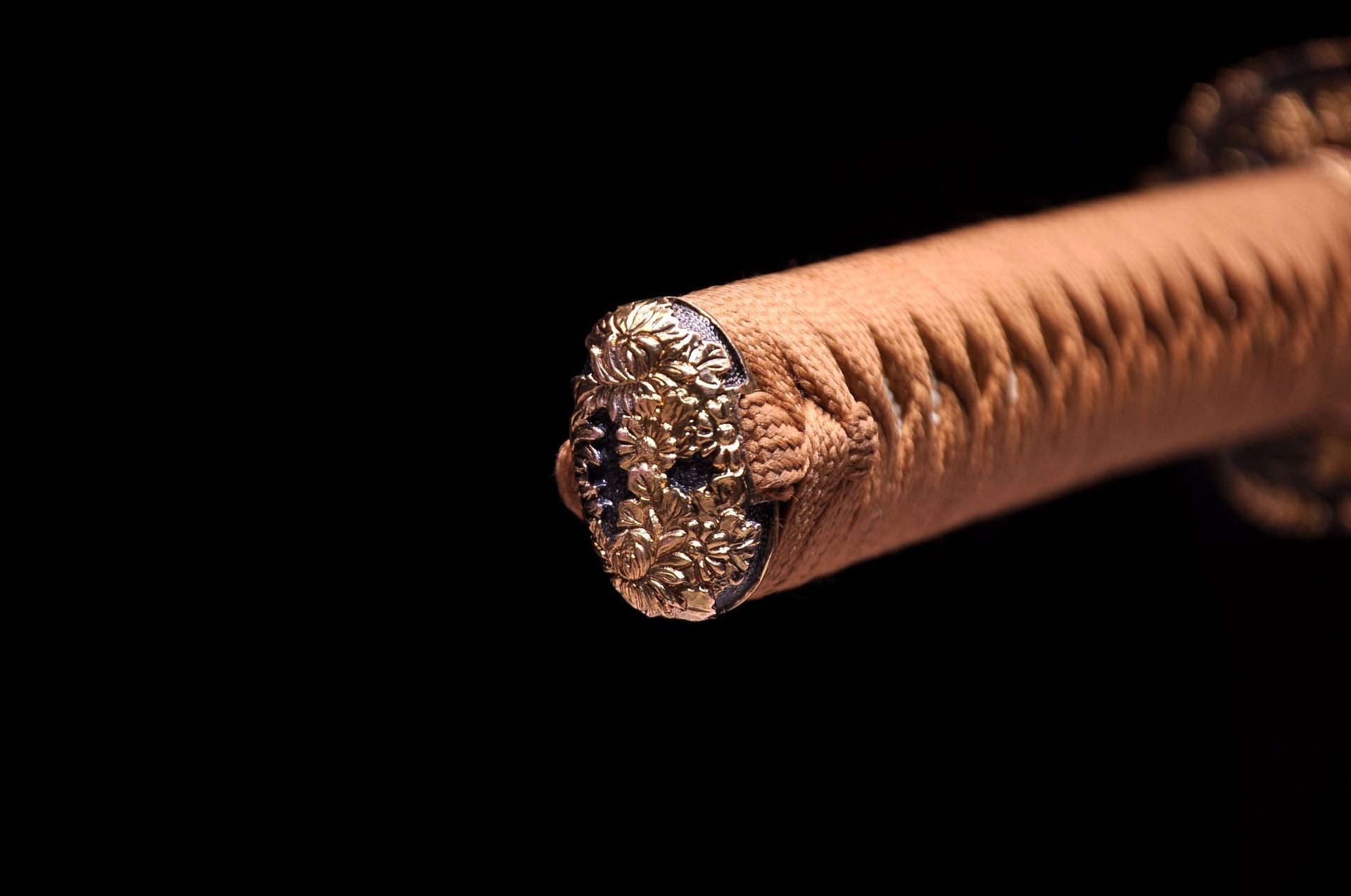 Exquisite details of a floral-engraved katana pommel.