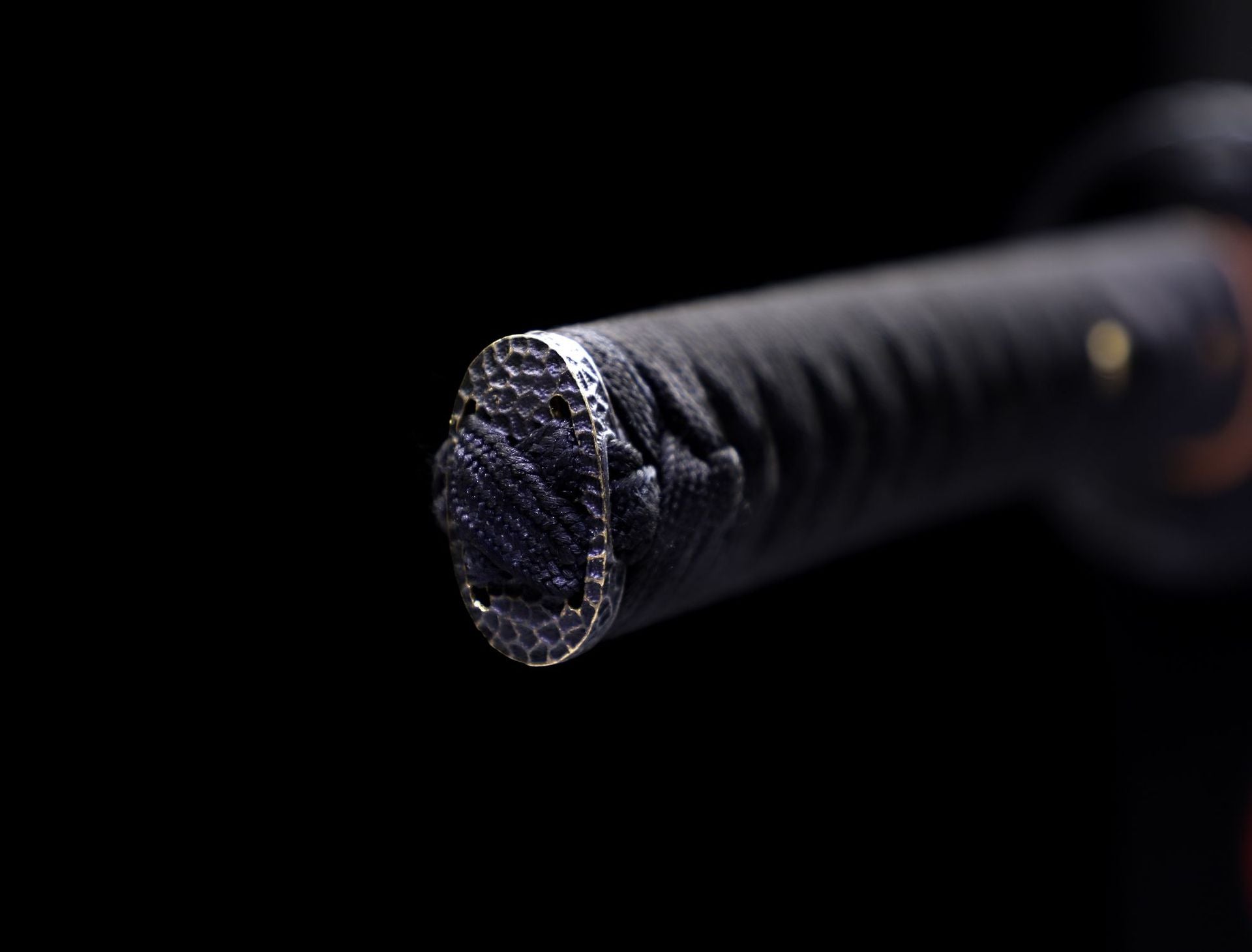 Close-up of the kashira on a Kuro ShiShi katana tightly securing the ito with intricate metalwork visible.