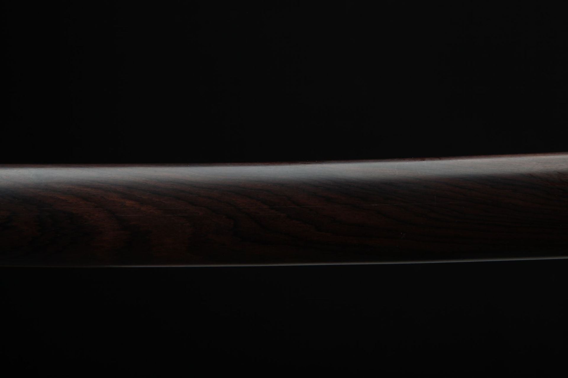 Close up of the Lion samurai sword scabbard highlighting a polished ebony woodgrain finish
