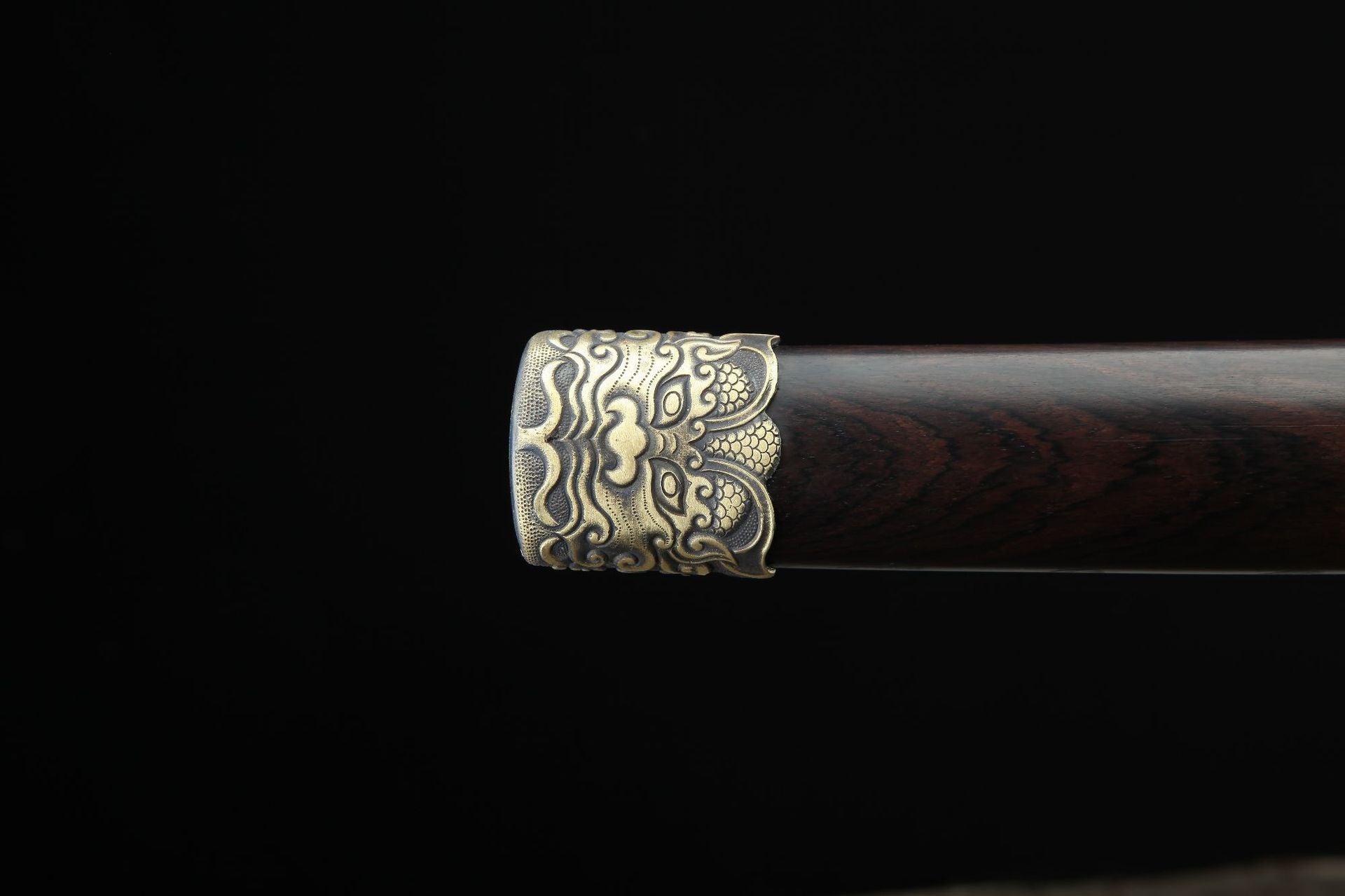 Close up of the Lion samurai sword scabbard end cap featuring an ornate copper lion motif on a polished ebony finish