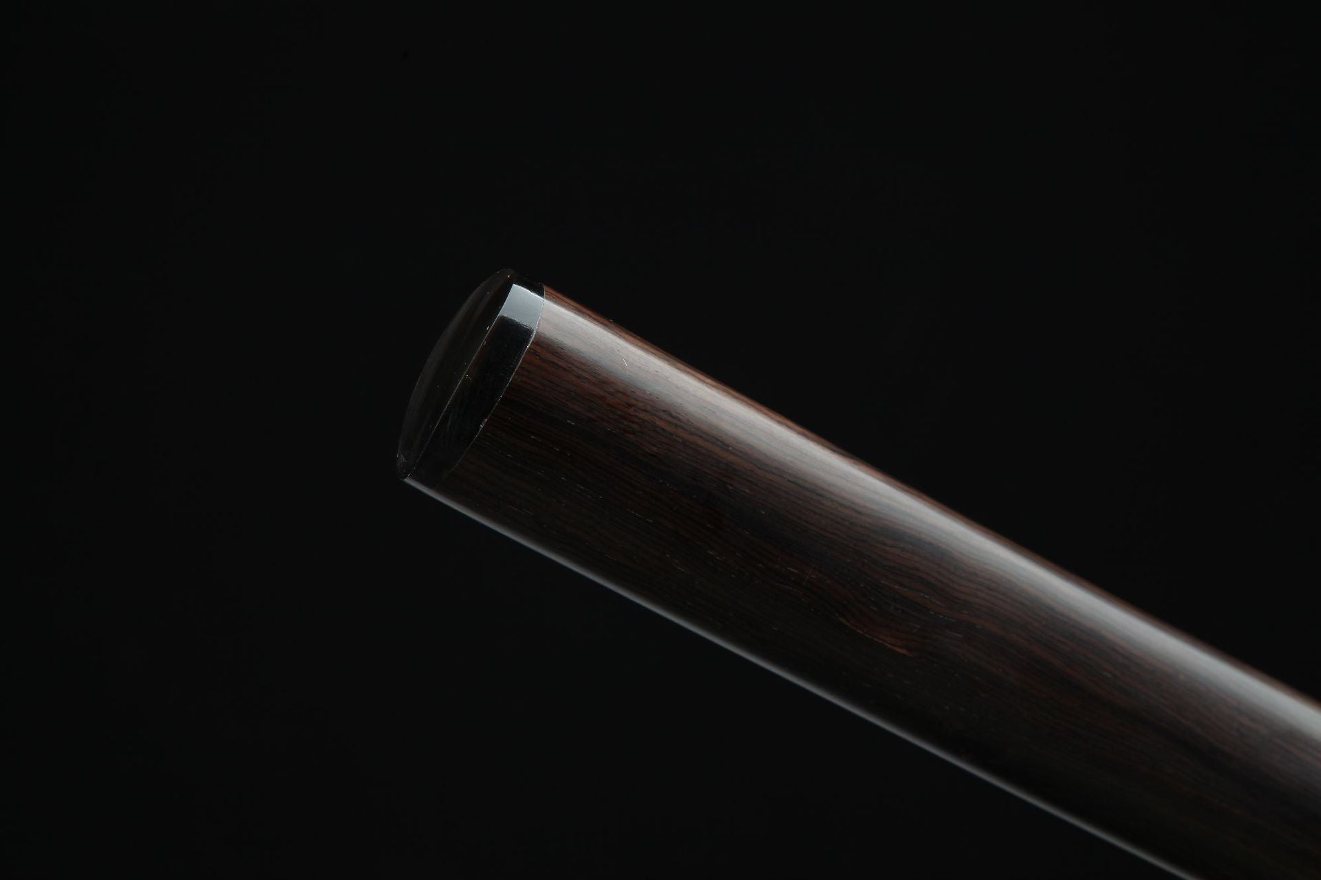 Detail of kojiri end cap on Loong War katana showing wood grain.