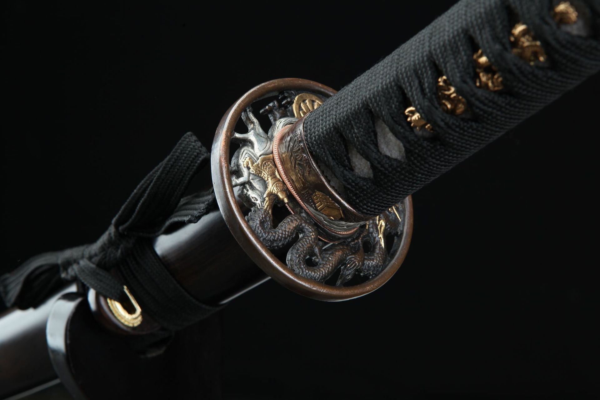 Intricately carved circular tsuba on the Loong War katana depicting an ancient mythological battle with a loong.