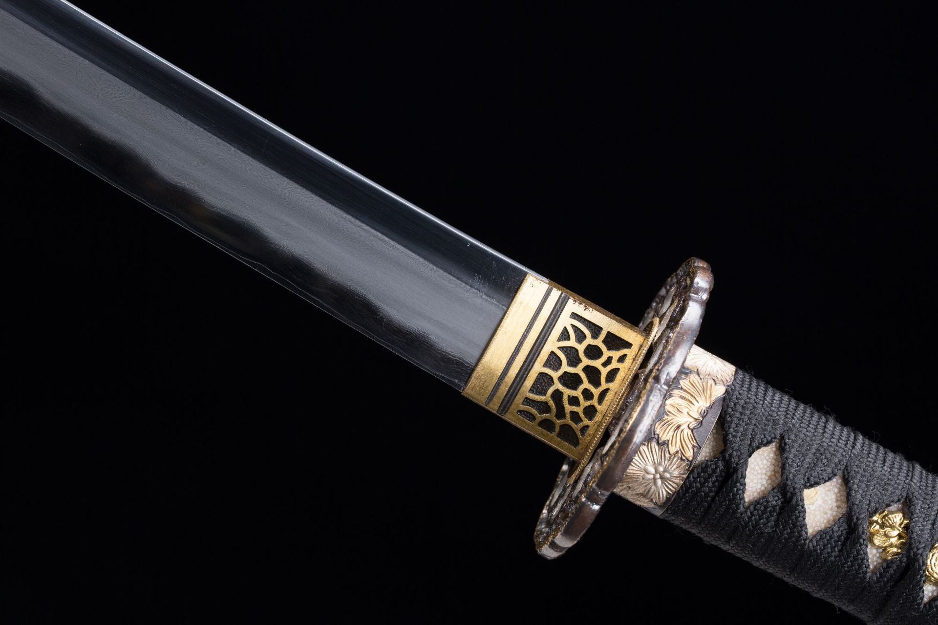 Close-up view of the fuchi on a Meditation katana with intricate gold patterns and tsuka details.