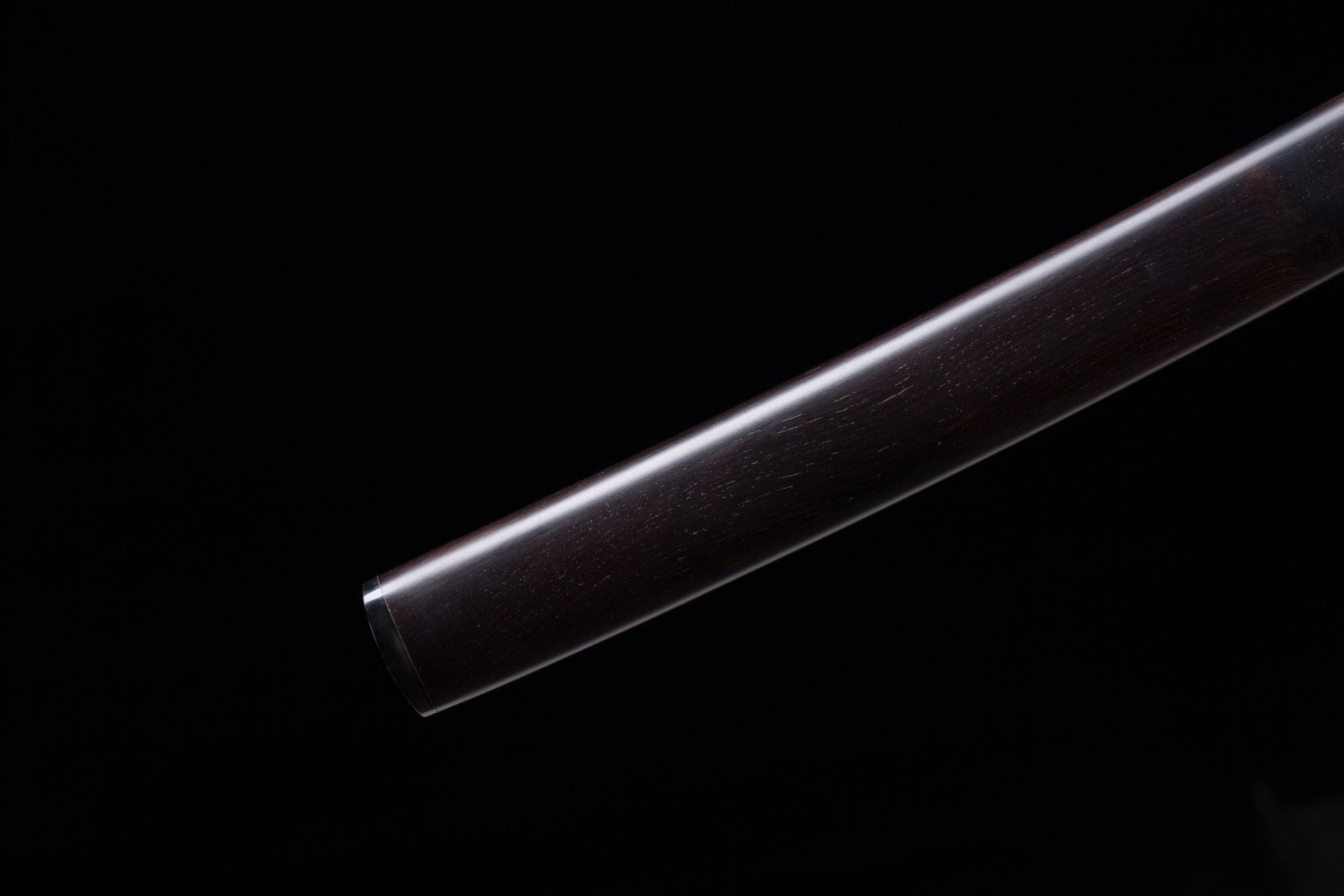 Close-up view of the wooden saya and kojiri on a Meditation katana highlighting the wood grain and smooth finish.