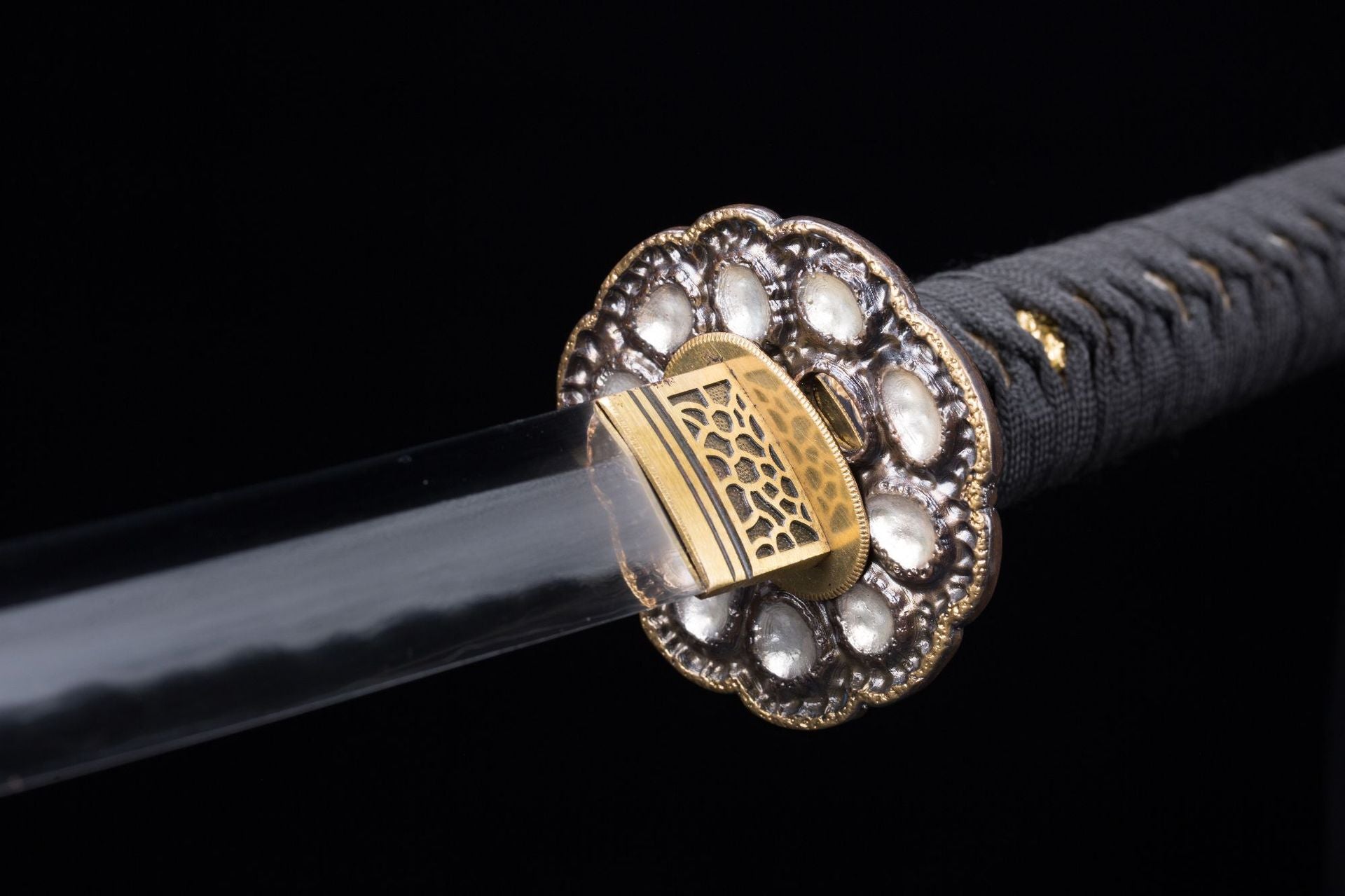 Reverse close-up of a Meditation katana tsuba showing gold detail and intricate patterns.