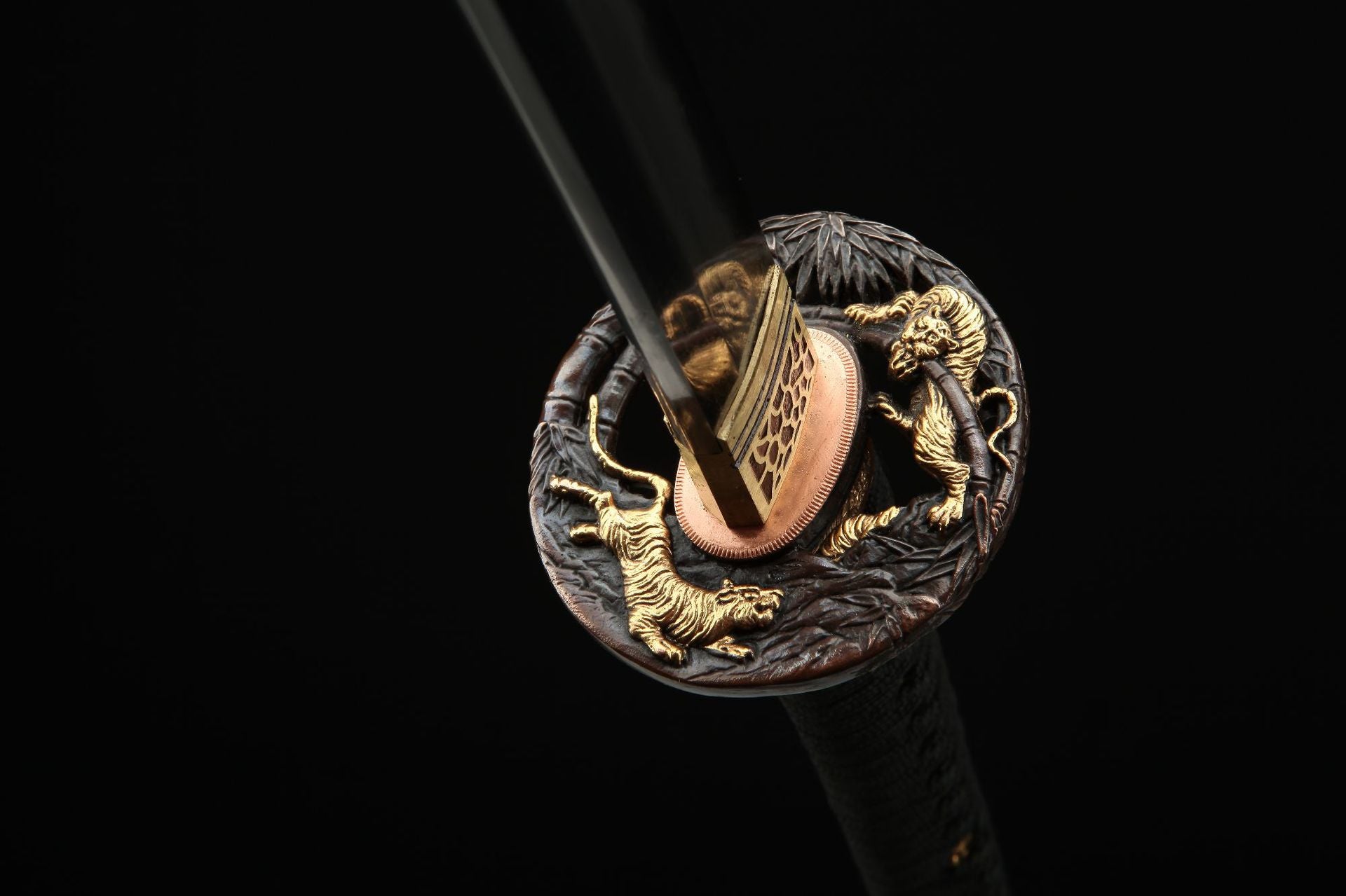 Close-up of the Mountain Lord katana's tsuba featuring an intricate tiger carving, showcasing exquisite craftsmanship.