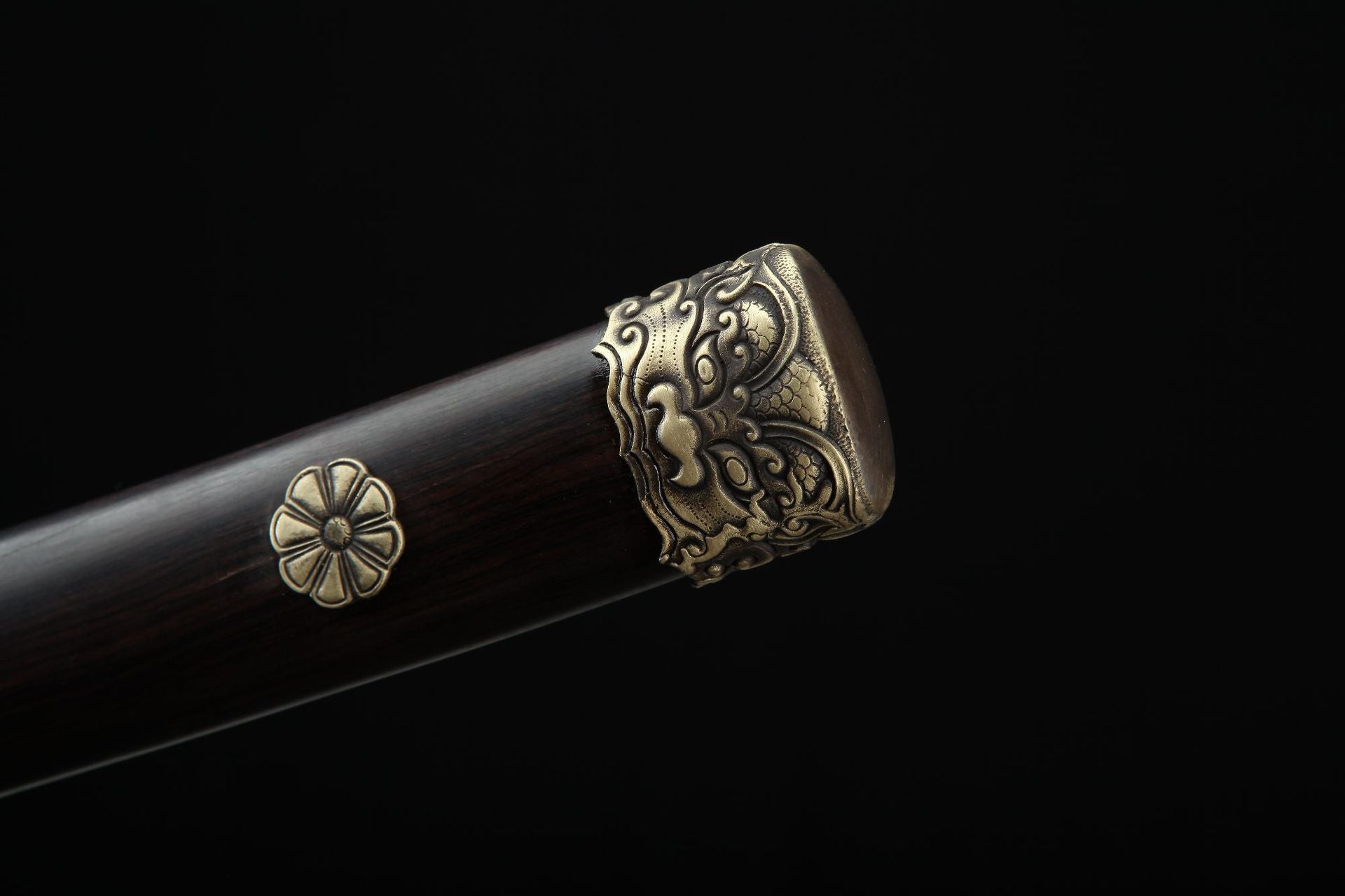 Close up of the Lion samurai sword pommel featuring a traditional lion relief on an ebony handle