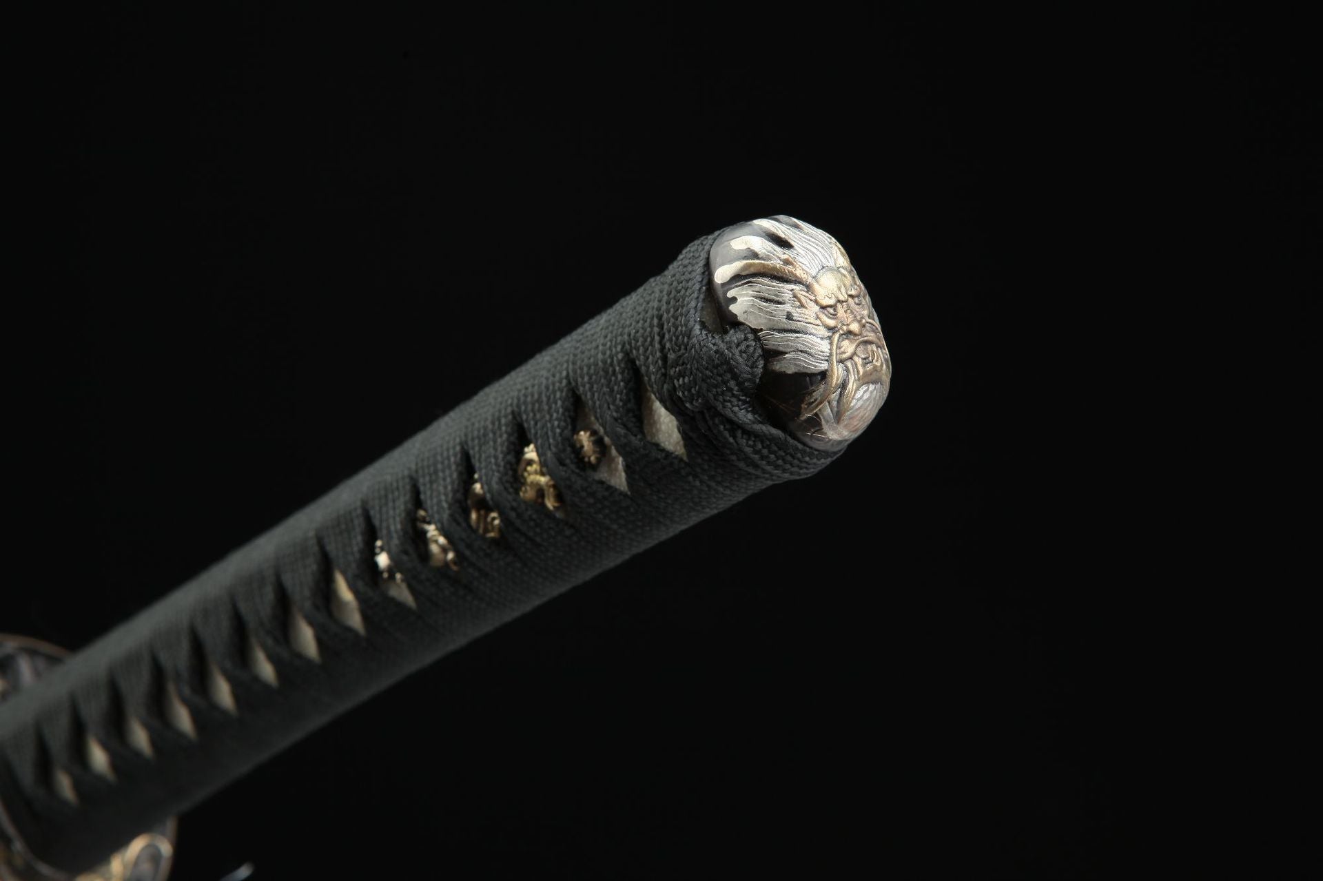 Close-up of the kashira of Seiryu katana featuring a detailed design of a fierce loong’s face.