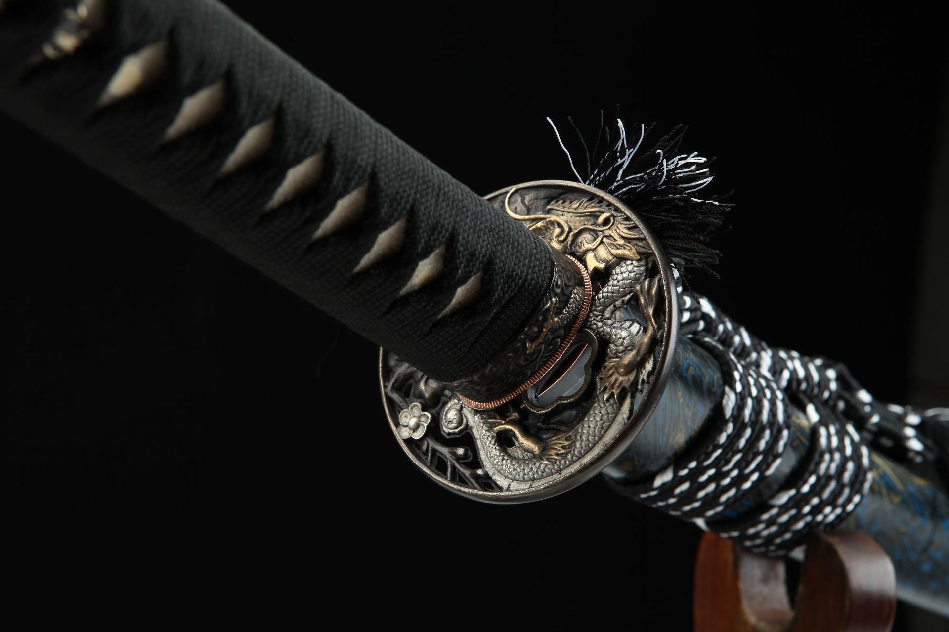 Close-up view of the Seiryu katana’s tsuba with intricate loong design and black ito wrapping on the handle.