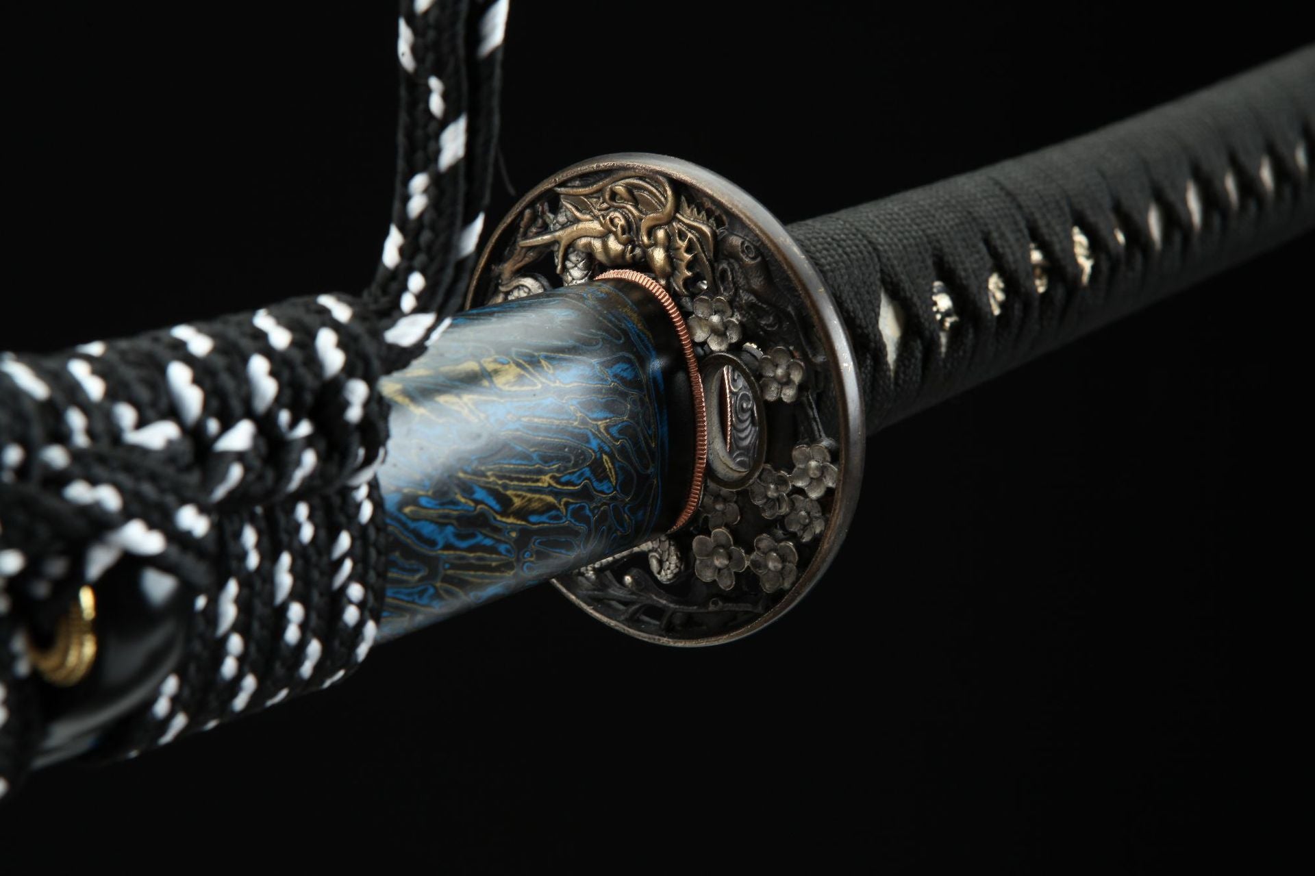 Close-up view of Seiryu katana’s tsuba with a detailed dragon design and floral accents.