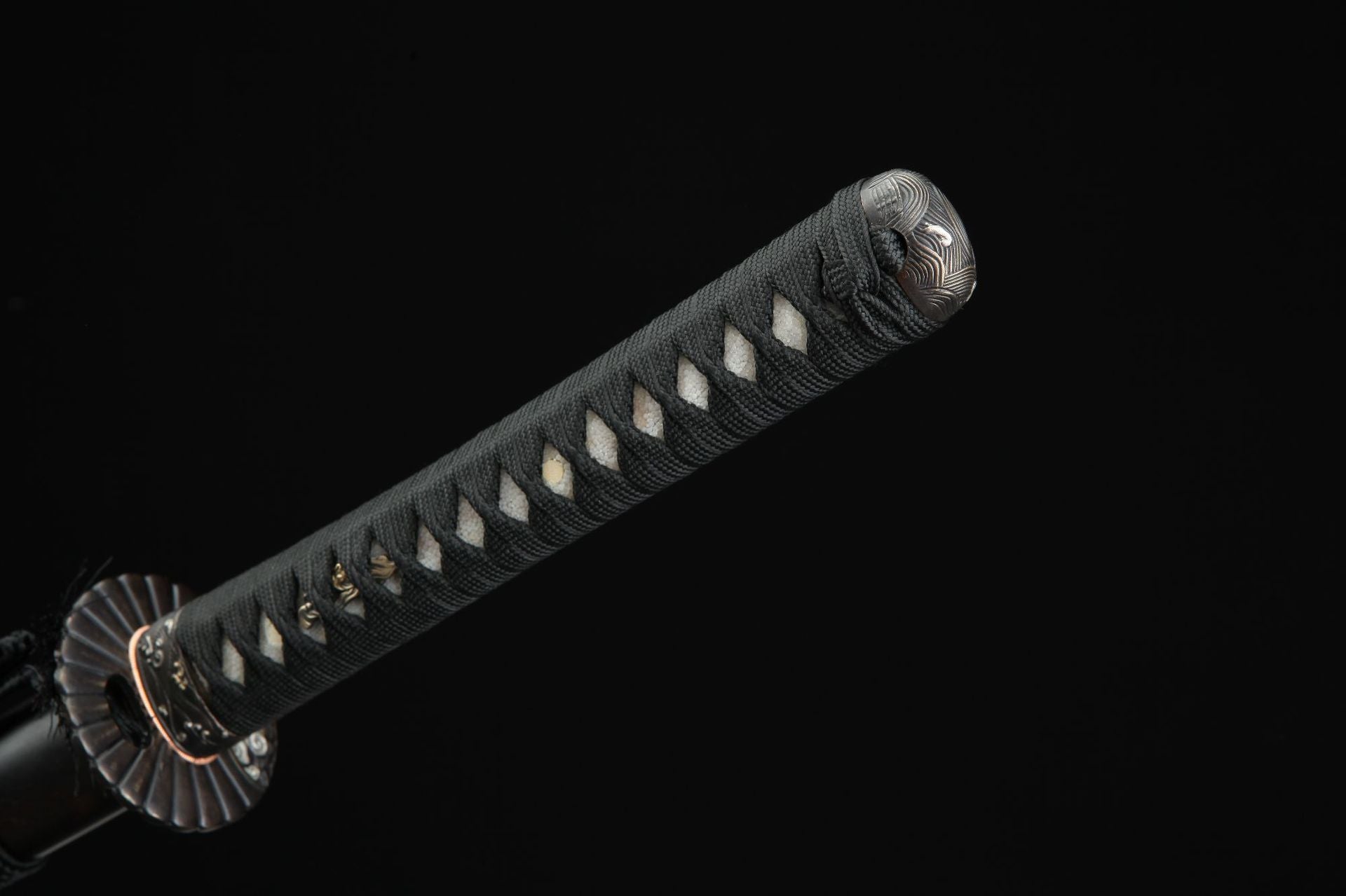 Close up of the Sunflower Ebony samurai sword handle featuring black cord wrap, white ray skin, and a decorative kashira