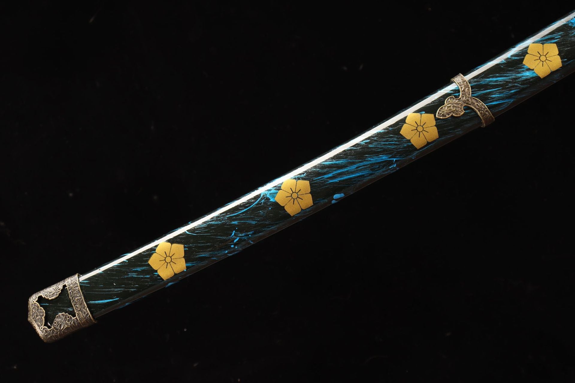 Closeup of a tachi scabbard with gold floral patterns and intricate blue accents.